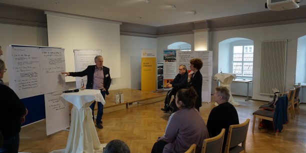 Arbeitszeitkonferenz-Urgestein und Mitorganisator Bernd Spitzbarth (IG Metall Nordhausen, an der Tafel) im Gespräch mit Diana Lehmann (SPD), MdL (rechts, stehend). Foto: EAT