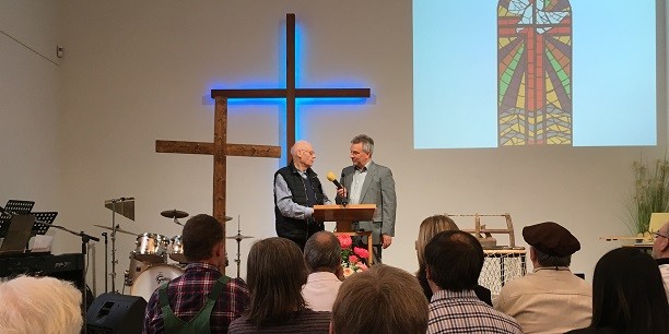 Schriftenmaler Walter Hupe (l.) berichtet von den Ideen, die der Gestaltung des Schmuckfensters der Hoffnungskirche zu Grunde liegen. Foto: © EAT