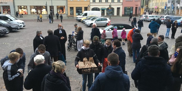 Eine der Backaktionen 2020 fand in Köthen statt: Konfis präsentieren die Brote vor der St. Jakobs-Kirche. Foto: © Tristan Fürstenau/Diakonie Mitteldeutschland
