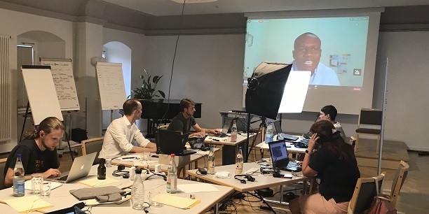 Sonst vollbesetzt, in diesem Jahr aber zum Studio umfunktioniert: Das Organisationsteam der Sommerakademie während der Live-Übertragung einer Online-Podiumsdiskussion im Chorsaal des Zinzendorfhauses. Foto: (c) Eleonore Roderfeld/EAT.