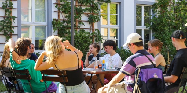 Teilnehmende der Pluralen Sommerakademie diskutieren auf der Terrasse des Zinzendorfhauses (Foto: Lukas Böhm)